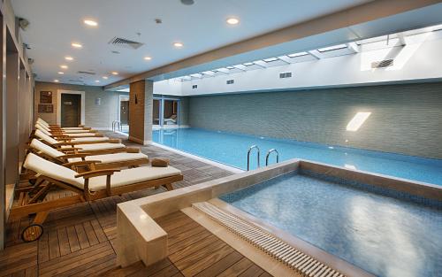 イスタンブールにあるデデマン ボスタンジュ イスタンブール ホテル ＆ コンベンションセンターのラウンジチェアの並ぶプールが備わります。