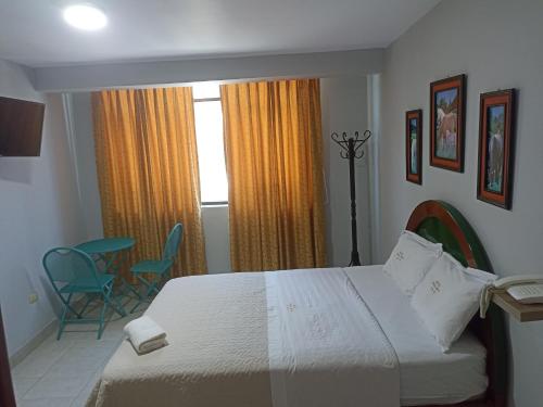 1 dormitorio con 1 cama, 2 sillas y ventana en HOTEL ALFONSO UGARTE en Chiclayo