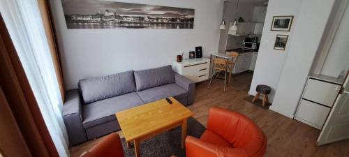un soggiorno con divano, tavolo e sedie di Apartament Kopernika 47 a Toruń