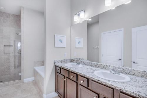 a bathroom with two sinks and a shower and a tub at Alerio B203 in Destin