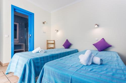 dos camas sentadas una al lado de la otra en una habitación en Refurbished beachfront house, Pool, AC, WiFi, Albufeira, sea view, en Albufeira