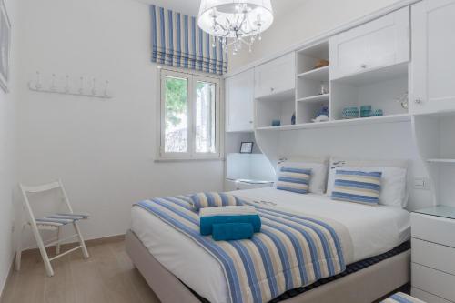 ein weißes Schlafzimmer mit einem Bett und einem Kronleuchter in der Unterkunft Villa Paradisio in Corsano