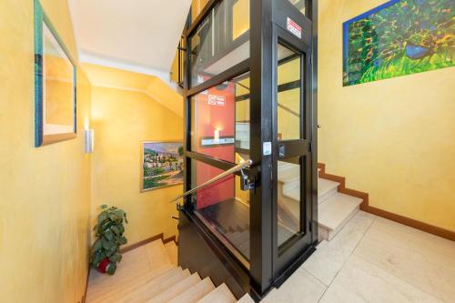 a glass elevator in a room with stairs at B&B New Aurora Venice in Marghera