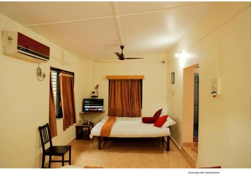 um quarto com uma cama com almofadas vermelhas em Nisarg Resort em Guhagar