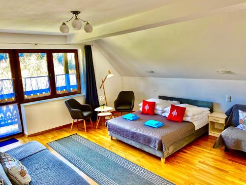 una camera con letto, divano e finestre di Willa Aurinia a Szczawnica