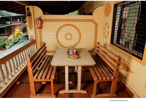 uma pequena mesa e duas cadeiras num alpendre em Nisarg Resort em Guhagar