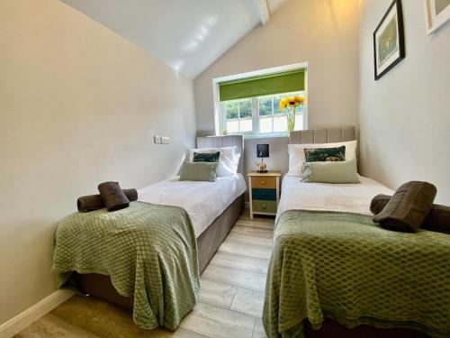 1 dormitorio con 2 camas y ventana en The Lodge at Pickford House NEC and B'Ham Airport, Coventry en Coventry