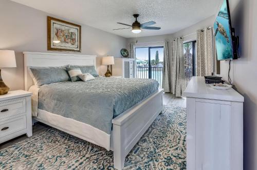 1 dormitorio con cama blanca y balcón en Land's End 4-202 Bay Front - Premier, en St Pete Beach