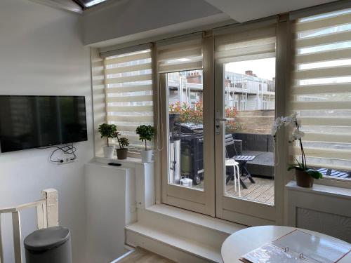 a living room with a sliding glass door and a table at Rooftop Terrace Apartment in Amsterdam