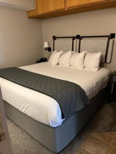 1 dormitorio con 1 cama grande con sábanas y almohadas blancas en Slope Side Ski In Ski Out at Beaver Run Resort, en Breckenridge