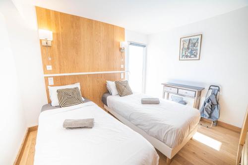 Cette chambre comprend 2 lits et une cheminée. dans l'établissement VILLA SUNNY BEACH CLIM ACCES PLAGE PARKING FAMILLE - TopProsConciergerie, à La Grande Motte