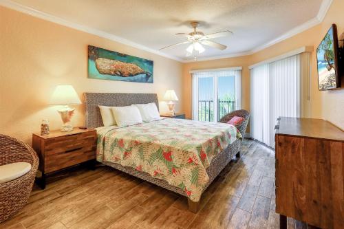 a bedroom with a bed and a table and a window at Land's End 6-303 Beach Front - Premier in St Pete Beach