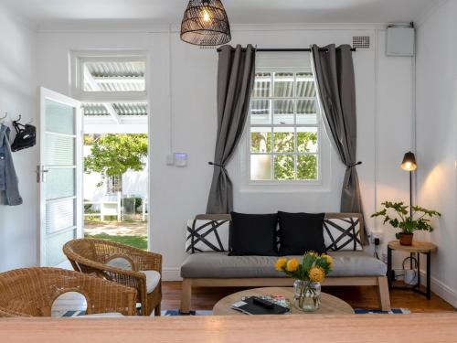 a living room with a couch and a table at Jonkershoek Valley Cottage in Stellenbosch
