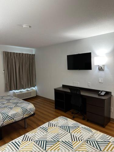 a hotel room with two beds and a desk with a television at Motel 6-Greensboro, NC - Airport in Greensboro