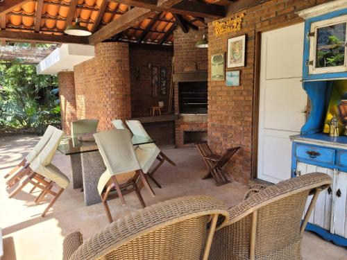 a patio with chairs and a table and a fireplace at Chalé Casa de Esther in Teresópolis
