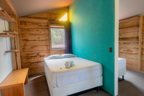 a bedroom with a bed in a wooden cabin at Esencia Nativa in El Zonte