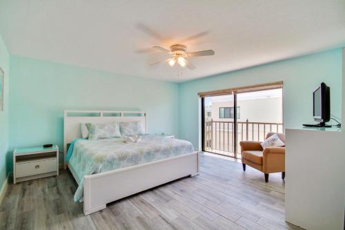 a bedroom with a bed and a television and a chair at Land's End 7-401 Beach Front - Premier in St. Pete Beach