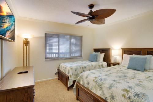 1 dormitorio con 2 camas y ventilador de techo en Land's End 7-304 Beach Front - Premier, en St Pete Beach