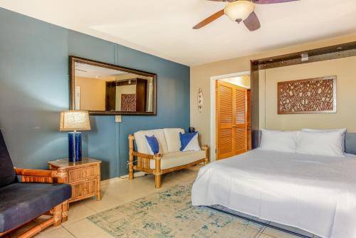 1 dormitorio con 1 cama y 1 silla en Kona Bali Kai Resort #234, en Kailua-Kona