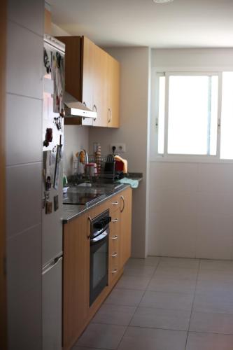 uma cozinha com um frigorífico e um fogão forno superior em Habitación Doble em Benavites