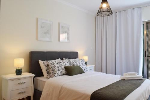 um quarto com uma cama grande e uma janela em Machico Beach, a Home in Madeira em Machico