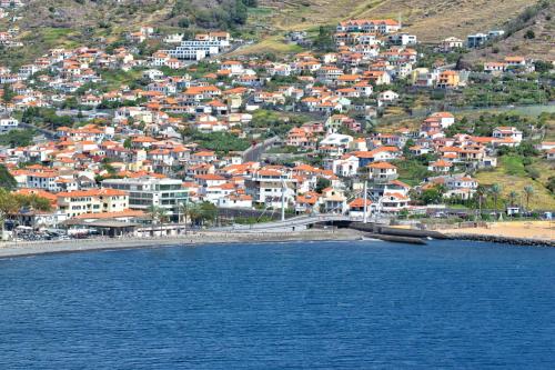 a town with a bridge over a body of water at Machico Beach, a Home in Madeira in Machico