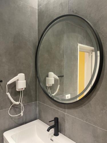 a bathroom with a mirror and a sink at Ladi Rooms in Tirana