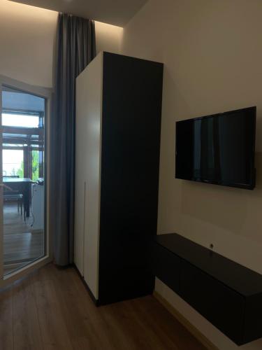a living room with a flat screen tv on the wall at Ladi Rooms in Tirana