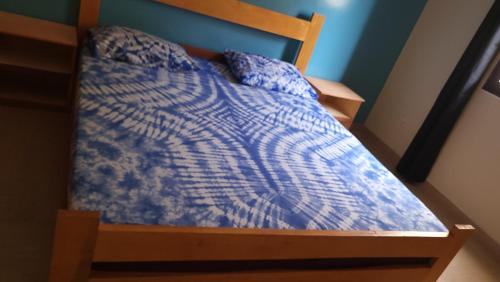 a bed with a blue comforter in a room at Keur Mado in Dakar