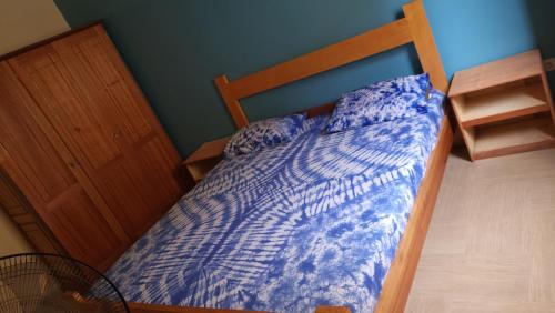 a bed with a blue comforter in a bedroom at Keur Mado in Dakar