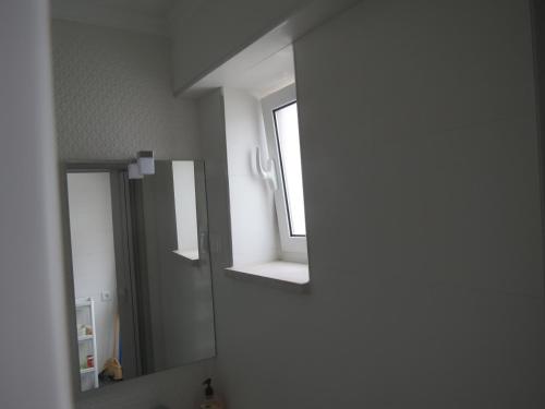 baño con espejo y ventana en Casa Peixe Nazare, en Nazaré