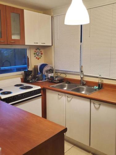 a kitchen with a sink and a stove top oven at Beautiful beachside apartment w/ terrace, balcony. in Arenas