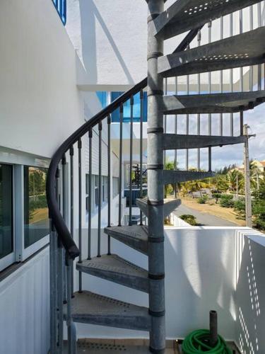 a spiral staircase on a balcony of a house at Beautiful beachside apartment w/ terrace, balcony. in Arenas