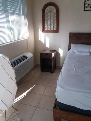 a bedroom with a bed and a table and a window at Beautiful beachside apartment w/ terrace, balcony. in Arenas