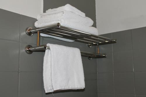 een groep handdoeken hangend aan een handdoekenrek in een badkamer bij Hotel De Ploeg in Diepenbeek