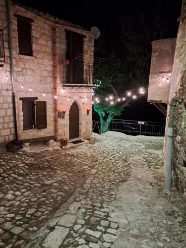 ein altes Gebäude mit einem Innenhof in der Nacht in der Unterkunft Romantico Chalet in pietra da mille e una notte in Petralia Soprana