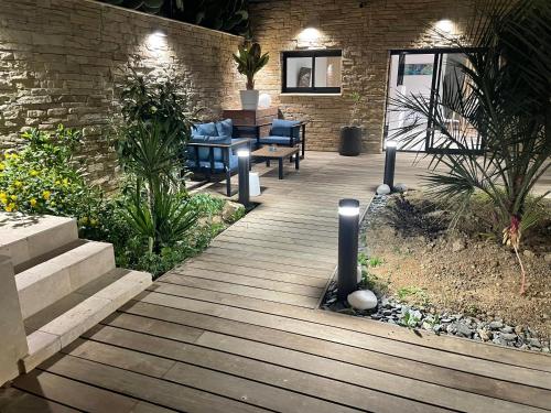 a wooden walkway with blue chairs and a brick wall at La suite provençale in Marseille