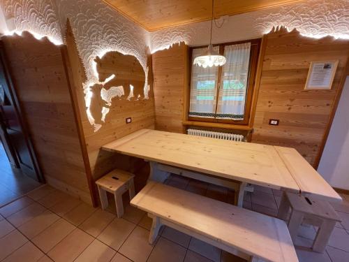 Cabaña de madera con mesa y banco. en Casa del Roccolo, en Folgarida