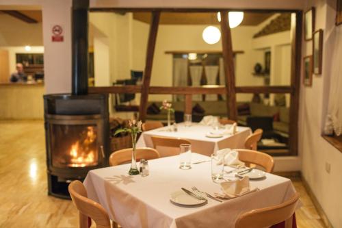 two tables in a restaurant with a fireplace at Hotel Andino Club - Hotel Asociado Casa Andina in Huaraz