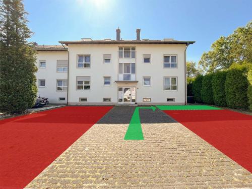 a large house with a red and green carpet at favstay Industrialstyle 2-Zimmer 60qm mit Balkon, Panarbora Fernblick, 55" TV & Netflix, 55Mbit WLAN, Parkplatz in Waldbröl