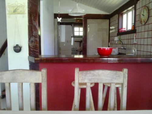 a kitchen with two wooden chairs at a counter at Residence Solemare in Búzios