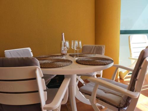 una mesa de comedor con copas de vino y sillas en Apartamento de lujo en primera línea de playa, en Torremolinos