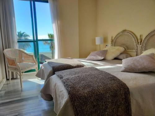2 camas en un dormitorio con vistas al océano en Apartamento de lujo en primera línea de playa, en Torremolinos