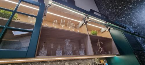 une vitrine de verres à vin dans l'établissement Tiny Dream House, à Buşteni