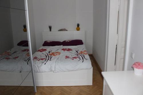 een witte slaapkamer met een bed met een spiegel bij my happy place in Wenen