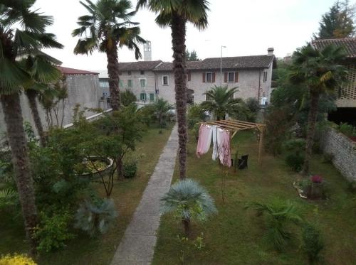 a yard with a clothes line and palm trees at Rovere dalla riva in Arzene