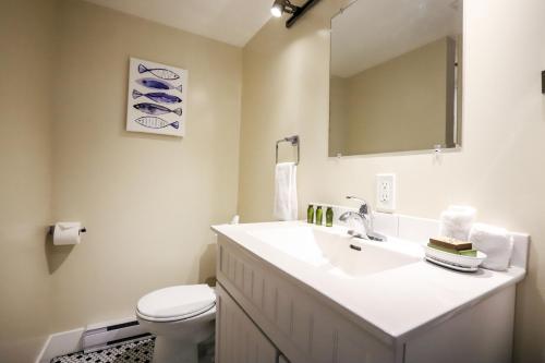 ein Badezimmer mit einem Waschbecken, einem WC und einem Spiegel in der Unterkunft Wild Coast Wilderness Resort in Port Renfrew