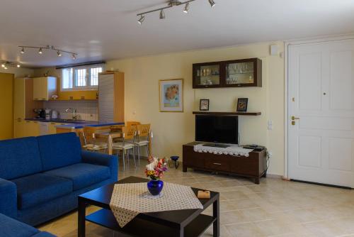 ein Wohnzimmer mit einem blauen Sofa und einem Tisch in der Unterkunft Artemis Riviera in Artemida