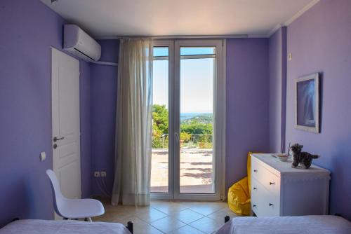 ein Zimmer mit einem Fenster mit einer Katze auf einer Kommode in der Unterkunft Artemis Riviera in Artemida