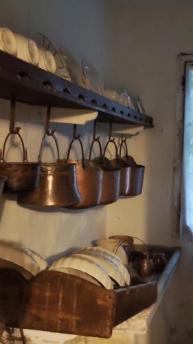 a bunch of copper pots and pans on a shelf at Rovere dalla riva in Arzene
